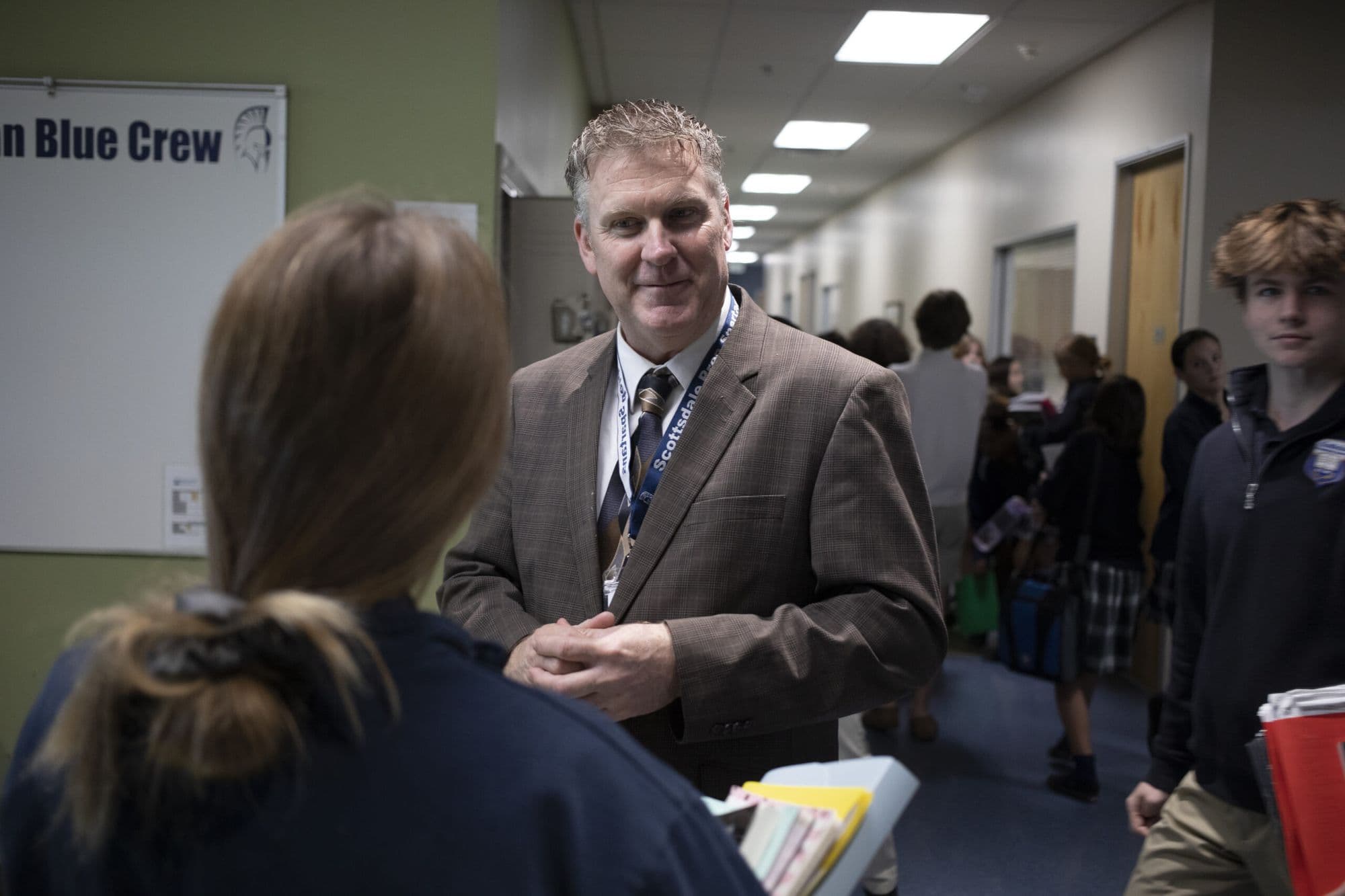 A Scottsdale Prep faculty member in conversation in a campus hallway